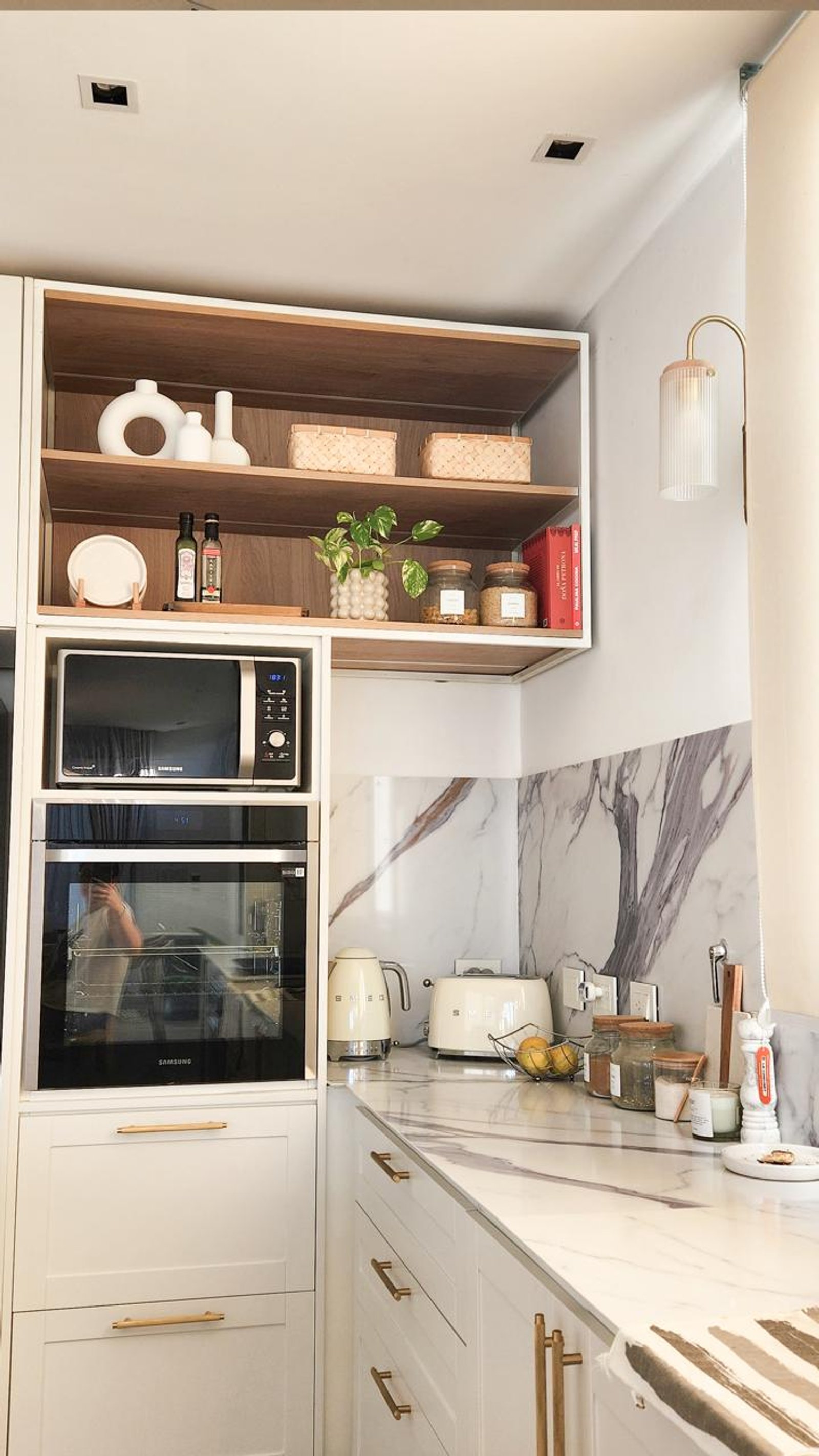 Cocina moderna con muebles blancos, mármol y electrodomésticos integrados — proyecto Canning, por Eniraestudio, en Canning
